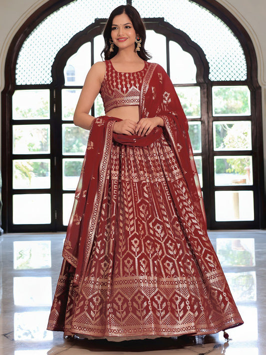 Woman wearing a traditional maroon and white embroidered lehenga in front of a decorative window.